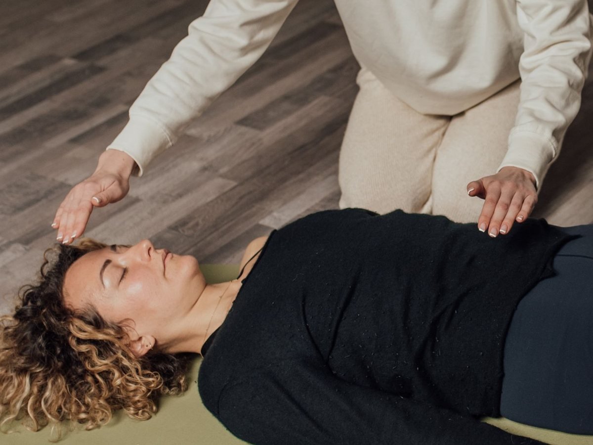 Pendant une séance, des mains placées au-dessus du front et de la poitrine d’une personne allongée, sans la toucher